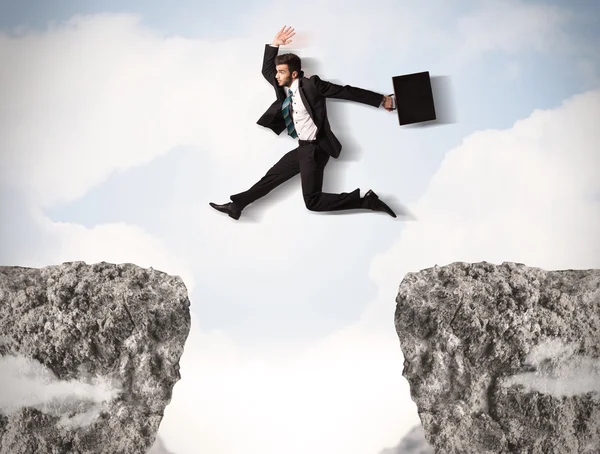 Funny business man jumping over rocks with gap Stock Picture