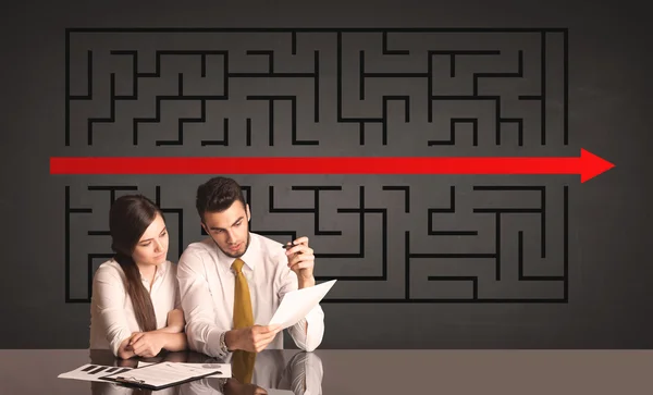 Business couple with a solved puzzle in background — Stock Photo, Image