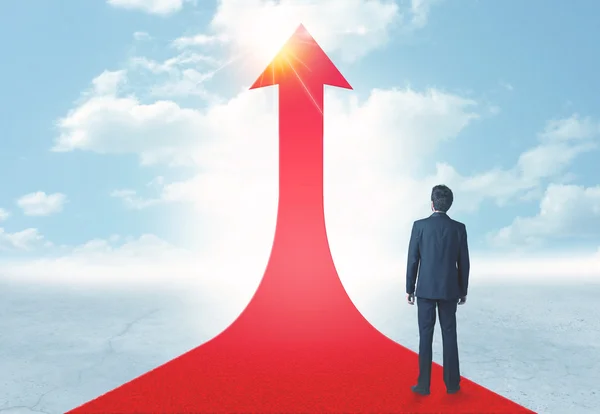 Businessman standing on a red arrow — Stock Photo, Image