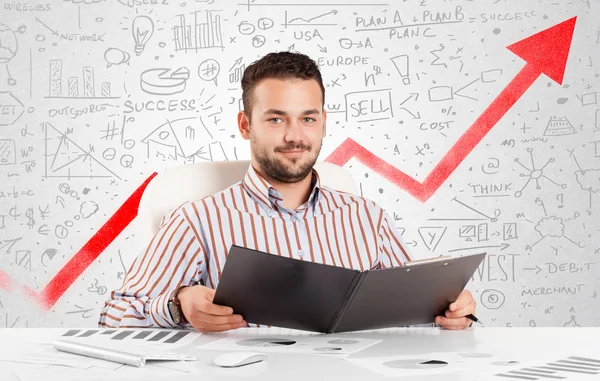 Geschäftsmann sitzt mit Marktdiagrammen am Tisch — Stockfoto