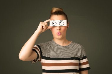 Elle çizilmiş göz küreleriyle kağıda bakan genç aptal kız.