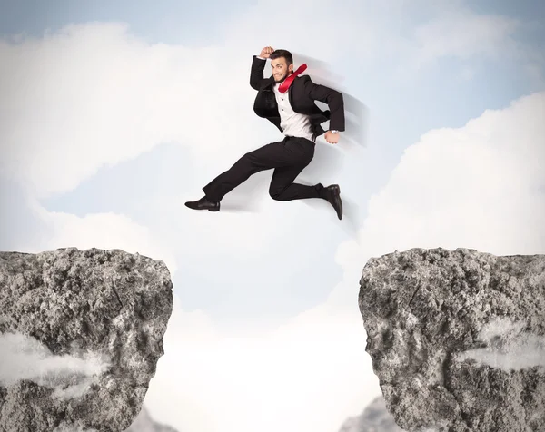 Homem de negócios engraçado saltando sobre pedras com lacuna — Fotografia de Stock