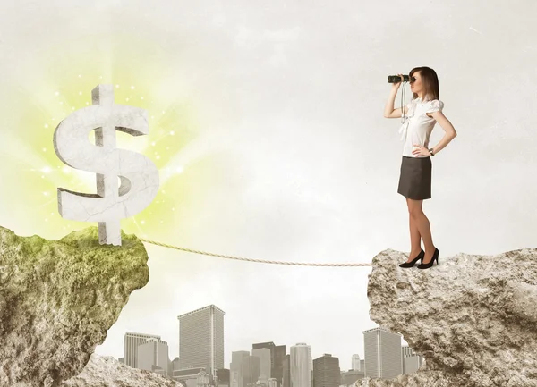 Businesswoman on rock mountain with a dollar mark — Stock Photo, Image