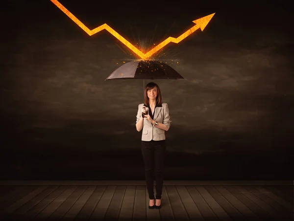 Mujer de negocios de pie con paraguas manteniendo flecha naranja —  Fotos de Stock