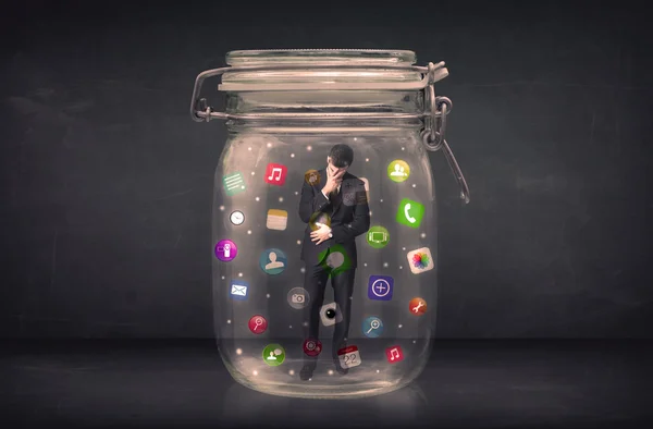 Empresario capturado en un frasco de vidrio con iconos de aplicaciones de colores con —  Fotos de Stock