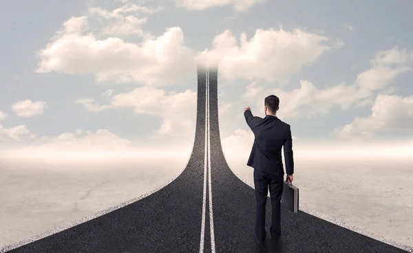 Бизнесмен смотрит на трехмерную дорогу, которая поднимается в небо — стоковое фото