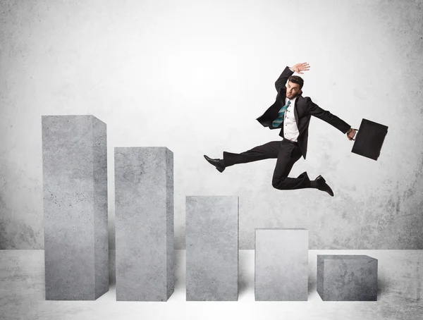 Successful business man jumping over charts on background — Stock Photo, Image