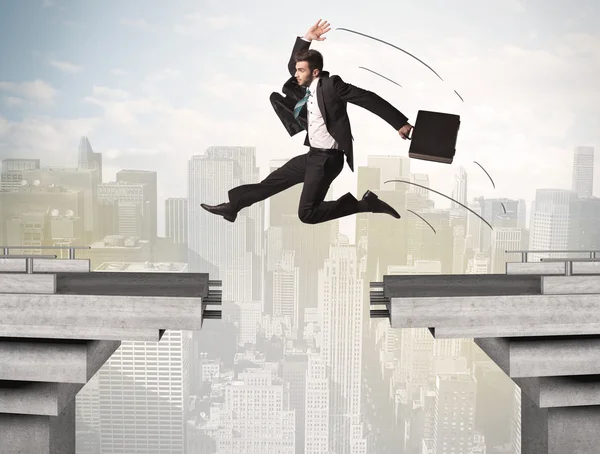 Energetic business man jumping over a bridge with gap — Stock Photo, Image