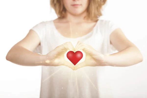 Manos creando una forma con un corazón brillante — Foto de Stock