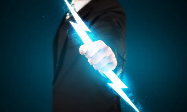 Business man holding glowing lightning bolt in his hands — Stock Photo, Image