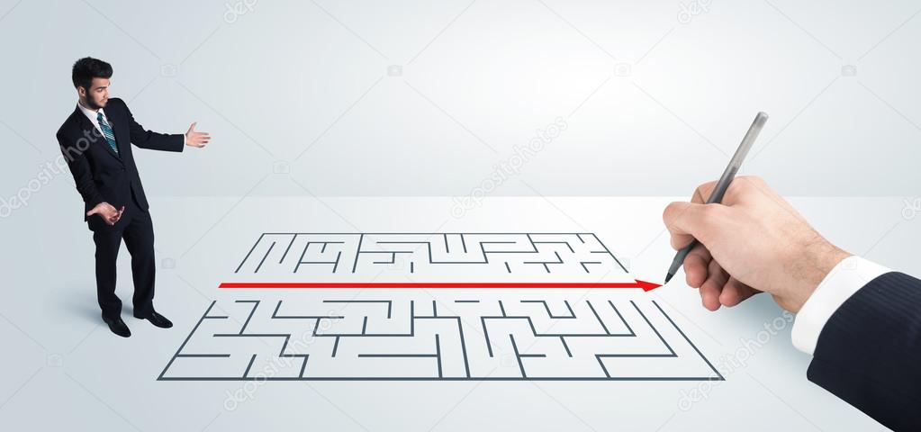 Business man looking at hand drawing solution for maze 