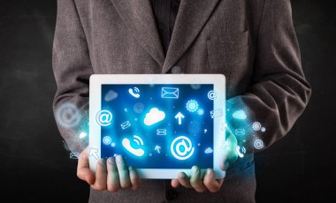 Mavi teknoloji simgeleri ve sembolleri olan bir tablet tutan kişi