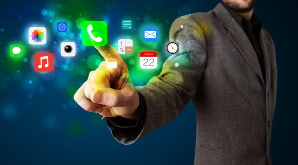 Bonito empresário pressionando ícones coloridos de aplicativos móveis com bok — Fotografia de Stock