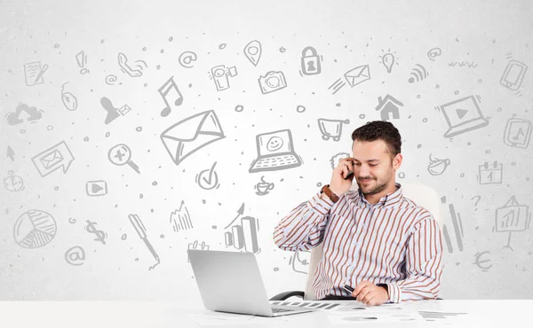 Business man  sitting at table with hand drawn media icons — Stock Photo, Image