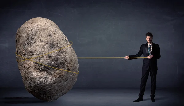 Businessman pulling huge rock with a rope — Stock Photo, Image