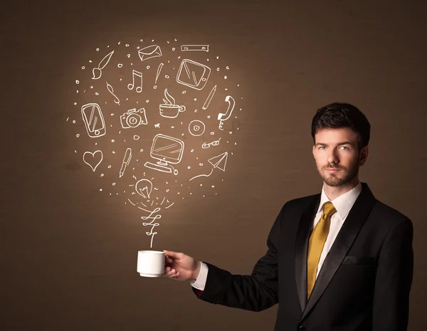 Businessman holding a white cup with social media icons — Stock Photo, Image