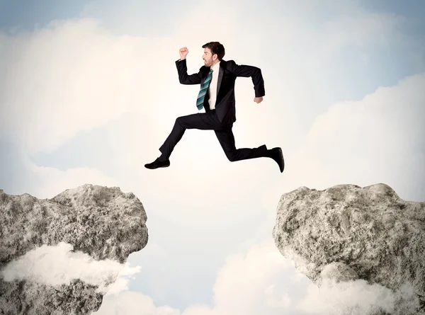 Hombre de negocios feliz saltando por un acantilado — Foto de Stock