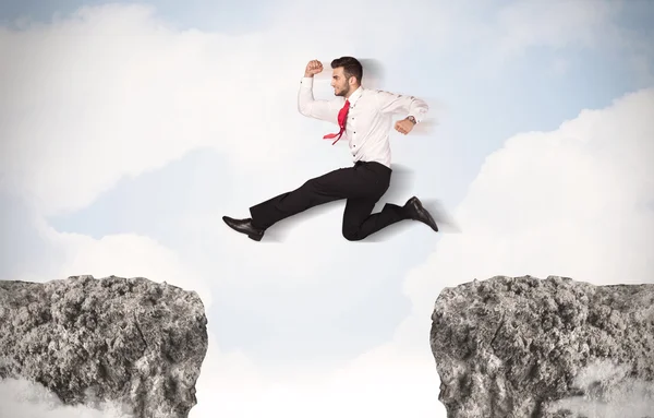 Homem de negócios engraçado saltando sobre pedras com lacuna — Fotografia de Stock