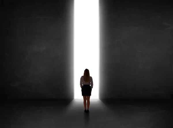 Geschäftsmann blickt auf Wand mit Lichttunnelöffnung — Stockfoto