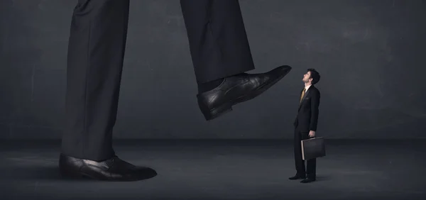 Gigante pessoa pisando em um pequeno conceito de homem de negócios — Fotografia de Stock