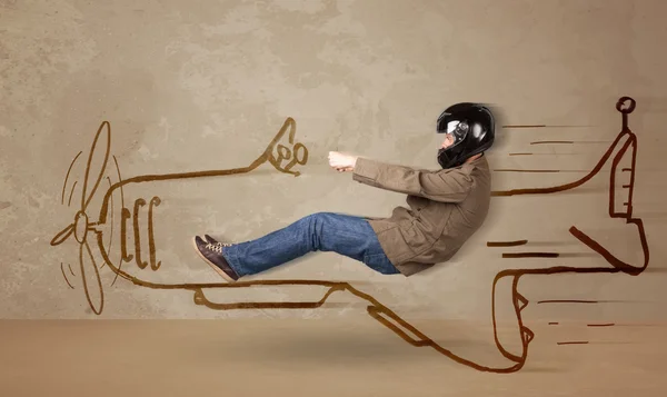 Funny pilot driving a hand drawn airplane on the wall — Stock Photo, Image