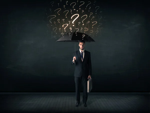 Homme d'affaires avec parapluie et beaucoup de points d'interrogation tirés — Photo