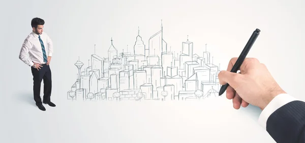 Businessman looking at hand drawn city on wall — Stock Photo, Image