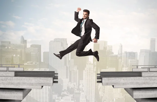 Energetic business man jumping over a bridge with gap — Stock Photo, Image