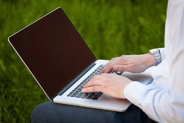 Empresário pressionando computador portátil moderno em backgrou colorido — Fotografia de Stock