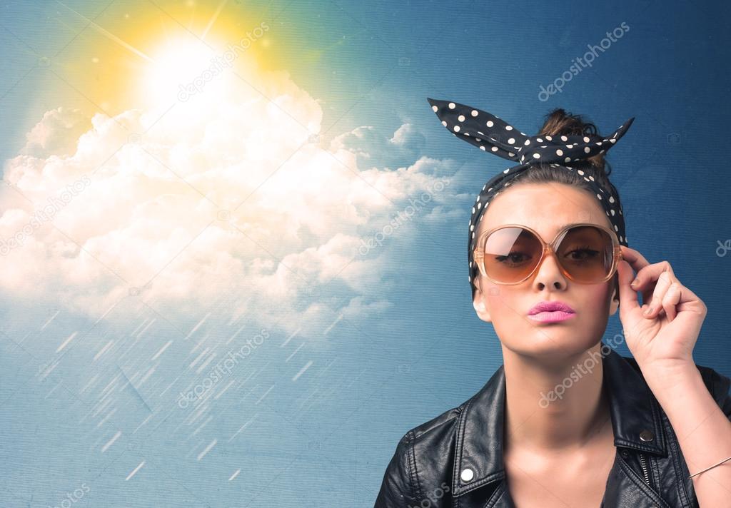 Young person looking with sunglasses at clouds and sun