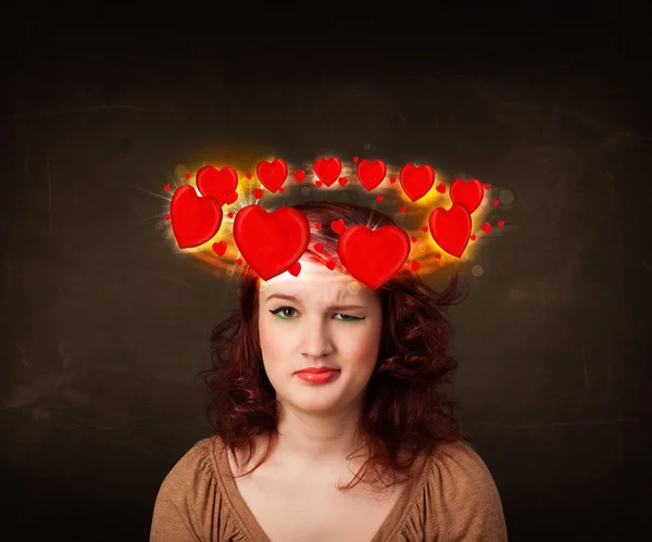 Adolescente ragazza con le illustrazioni del cuore che gira intorno alla sua testa — Foto Stock