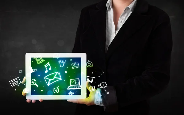 Person mit einem Tablet mit Mediensymbolen und -symbolen — Stockfoto