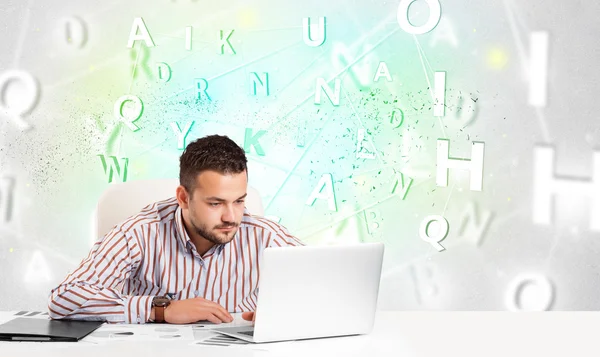 Business man at desk with green word cloud — Stock Photo, Image