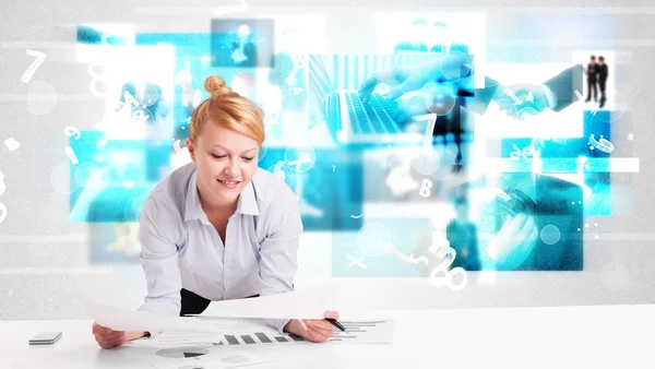 Business person at desk with modern tech images at background Stock Image