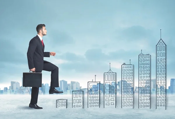 Business man climbing up on hand drawn buildings in city — Stock Photo, Image