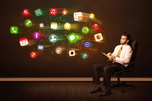 Homem de negócios sentado na cadeira do escritório com tablet e ap colorido — Fotografia de Stock