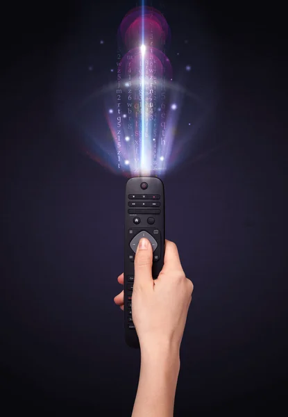 Hand with remote control and shining numbers — Stock Photo, Image