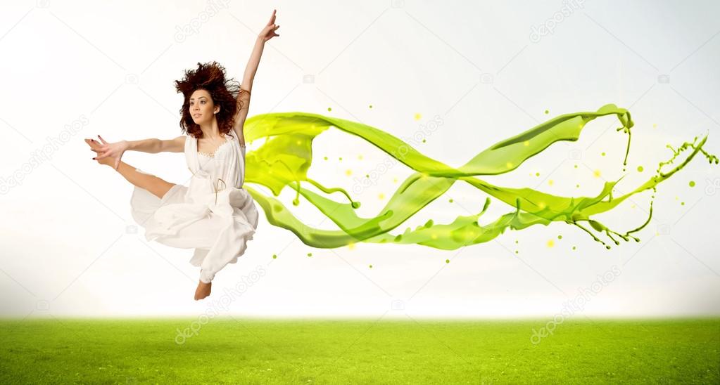 Pretty girl jumping with green abstract liquid dress