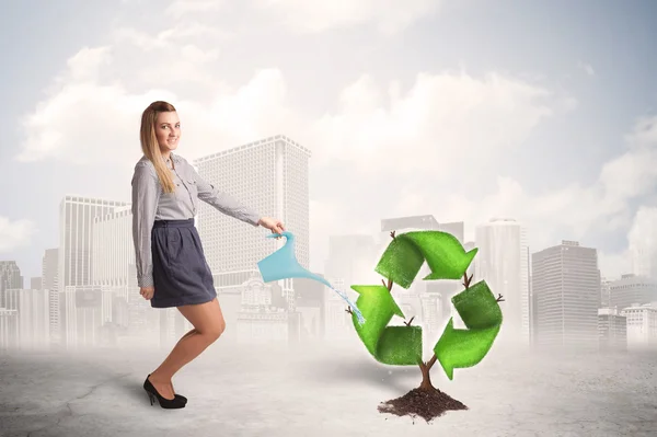 Business woman watering green recycle sign tree on city backgrou — Stock Photo, Image