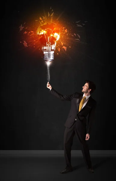 Businessman with an explosion bulb — Stock Photo, Image