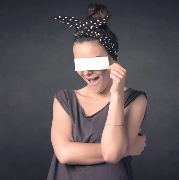 Hübsches Mädchen hält leeres Kopierpapier vor ihren Augen — Stockfoto