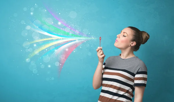 Beautiful girl blowing abstract colorful bubbles and lines — Stock Photo, Image