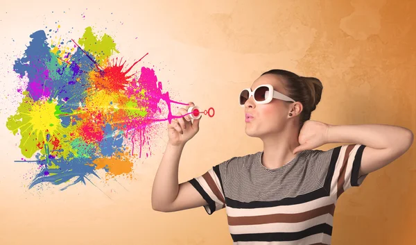 Cute girl blowing colorful splash graffiti — Stock Photo, Image