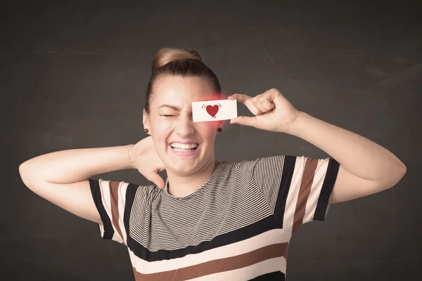 Bella ragazza che tiene la carta con il disegno del cuore rosso — Foto Stock