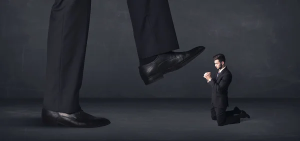 Giant person stepping on a little businessman concept — Stock Photo, Image