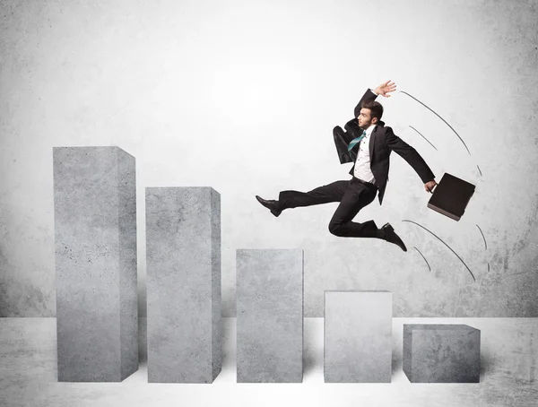 Successful business man jumping over charts on background — Stock Photo, Image