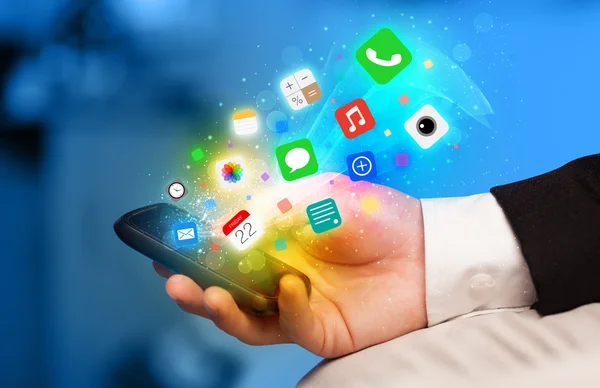 Рука держит смартфон с красочными иконками приложения — стоковое фото
