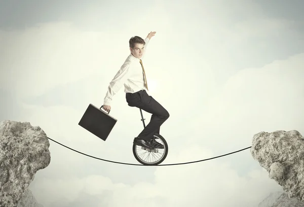 Brave business man riding an mono cycle between cliffs — Stock Photo, Image