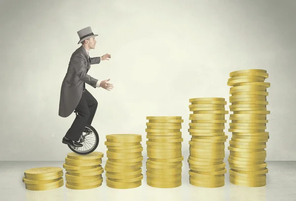 Business man riding monocycle up on coin graph — Stock Photo, Image