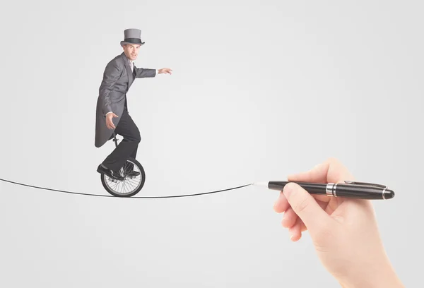 Businessman riding monocycle on a rope drawn by hand — Stock Photo, Image